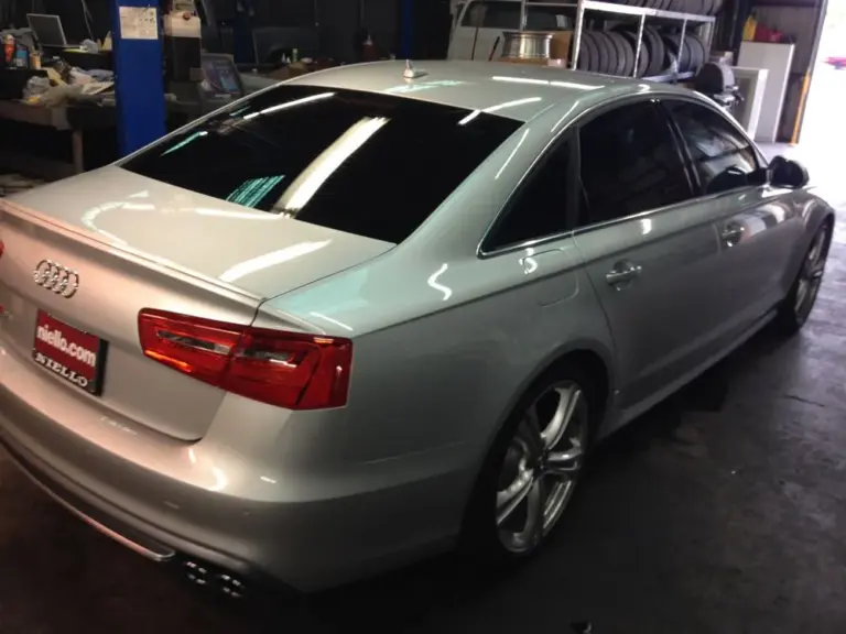 Silver Audi S6 with tinted windows, rear three-quarter view