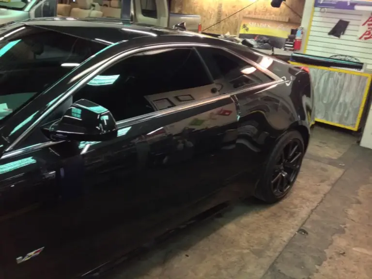 Black coupe's tinted side windows, close up