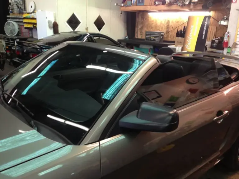 Convertible with tinted windows, top down, in the shop
