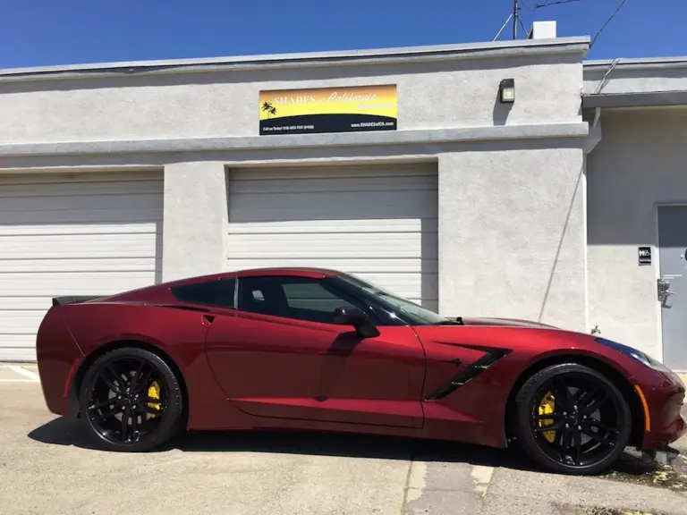Red Corvette Stingray with tinted windows outside the shop
