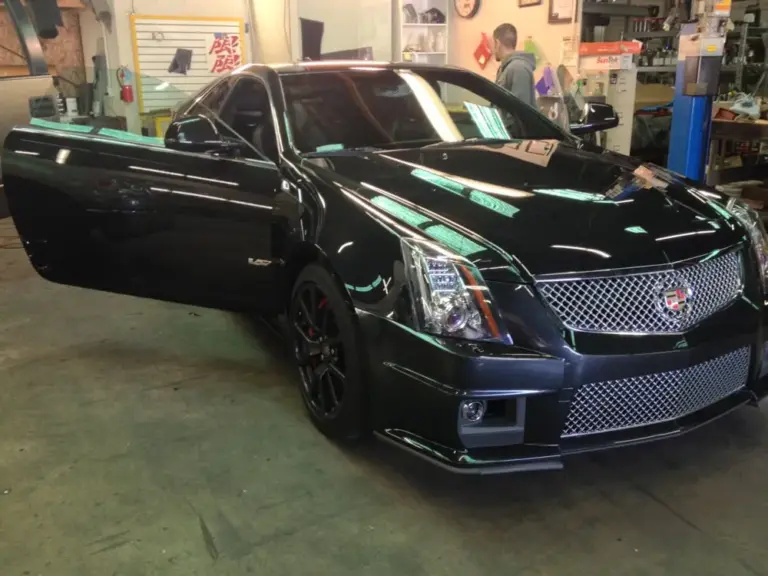 Black Cadillac CTS-V coupe with tinted windows in the shop