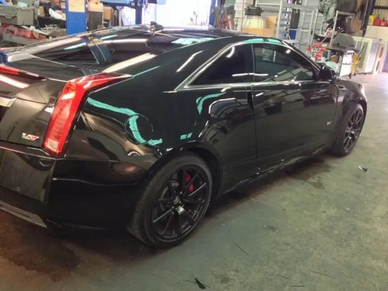 Black Cadillac CTS-V coupe with tinted windows, rear view