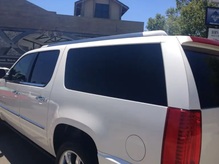 White Cadillac Escalade's tinted rear windows, close up
