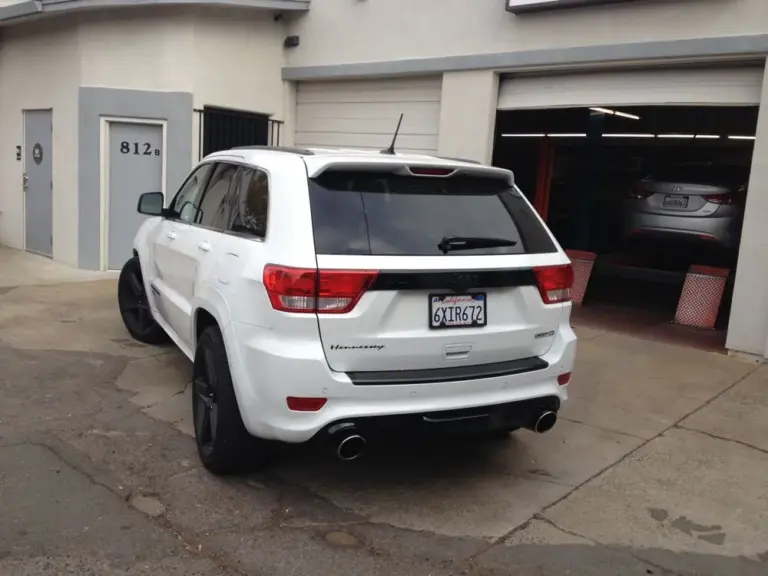 White Jeep Grand Cherokee SRT8 with a tinted rear window outside the shop