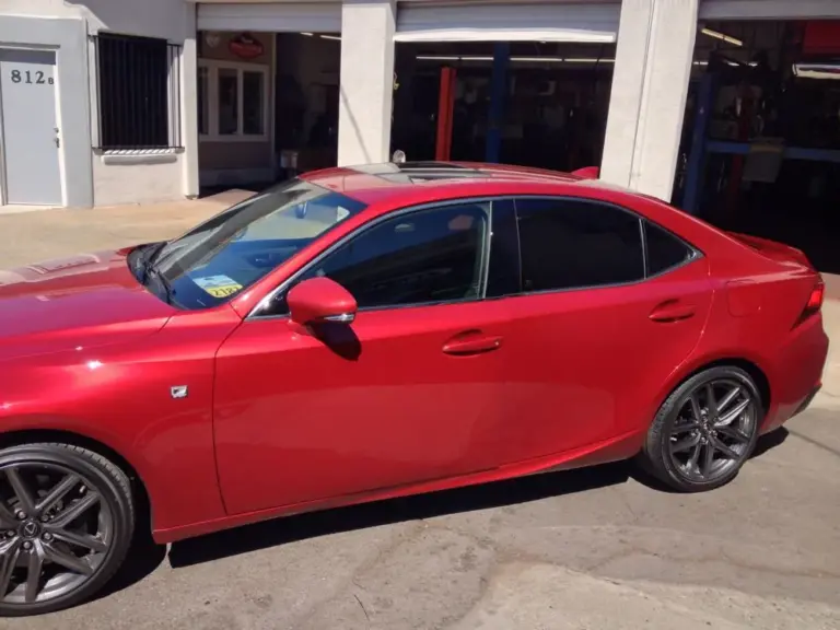 Red Lexus IS with tinted windows outside the shop