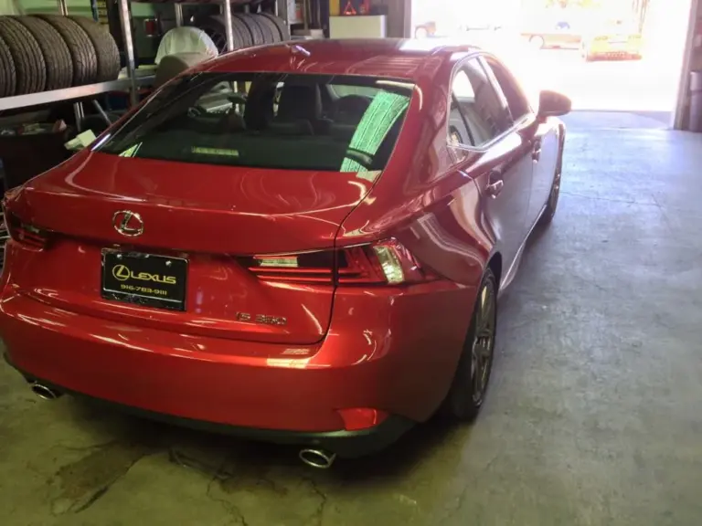 Red Lexus IS from behind with a tinted rear window
