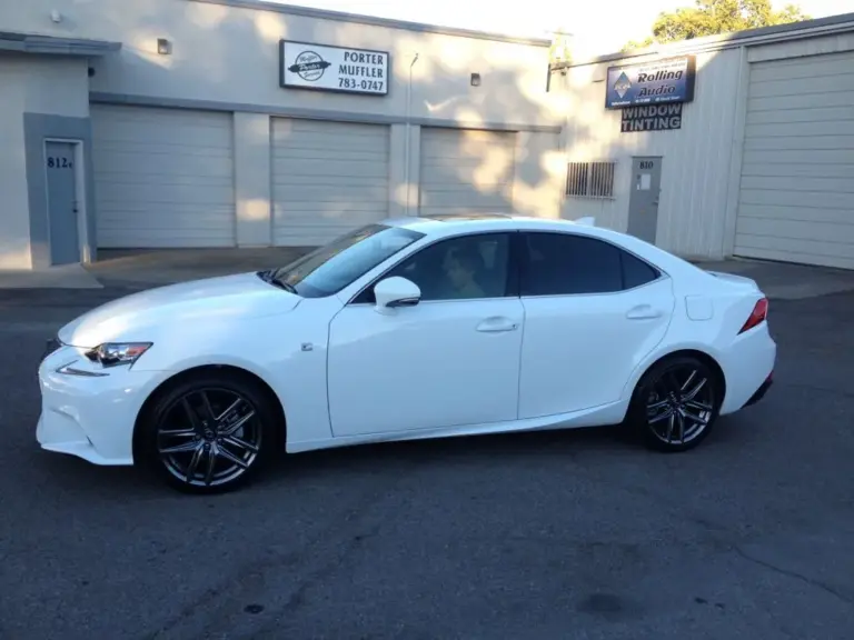 White Lexus IS with tinted windows outside the shop