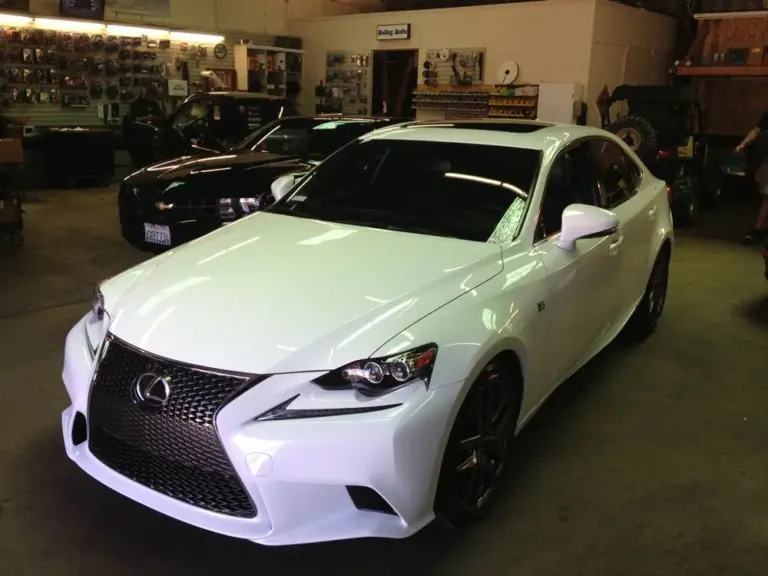White Lexus IS sedan with tinted windows in the shop