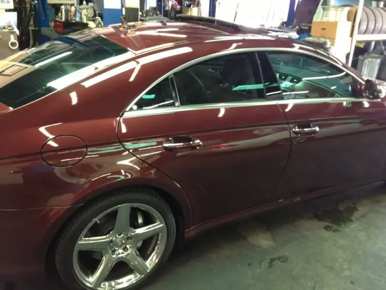 Burgundy Mercedes CLS with tinted windows in the shop