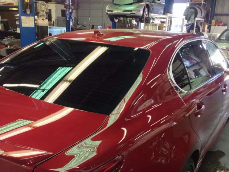 Red sedan's tinted rear window, close up