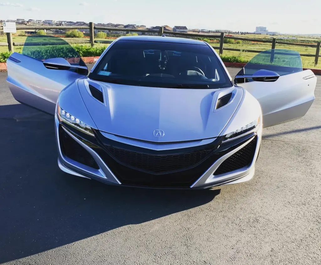 White Acura NSX with its doors open and tinted glass