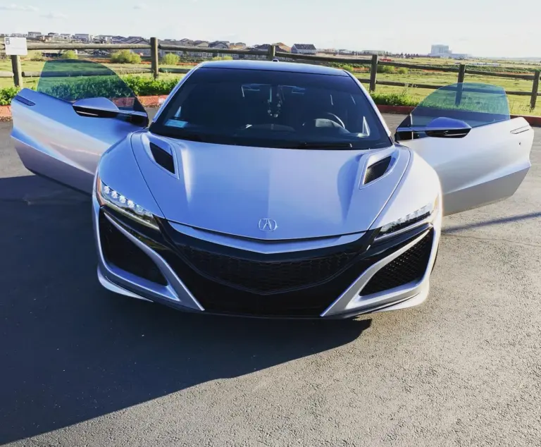 White Acura NSX with its doors open and tinted glass